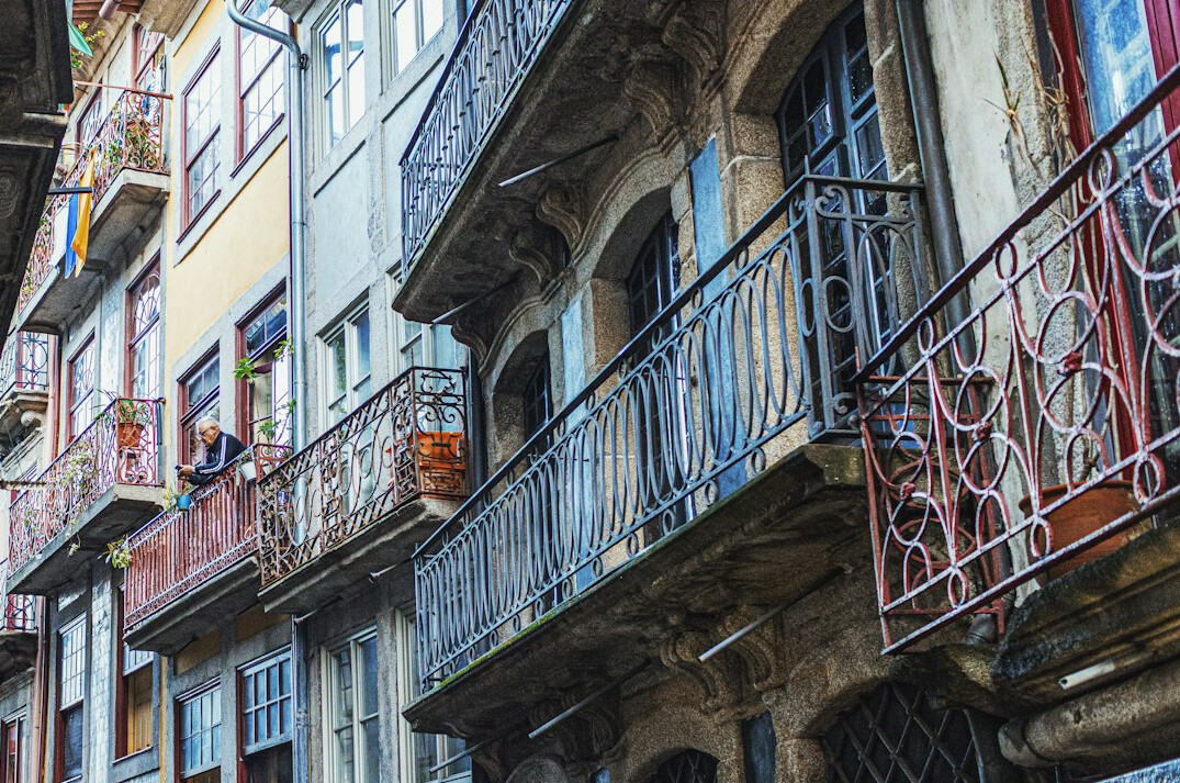 Narrow historic street with old facades and iron balconies