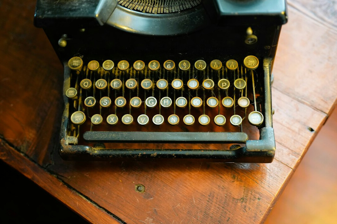 Vintage typewriter with a blank page on a wooden desk