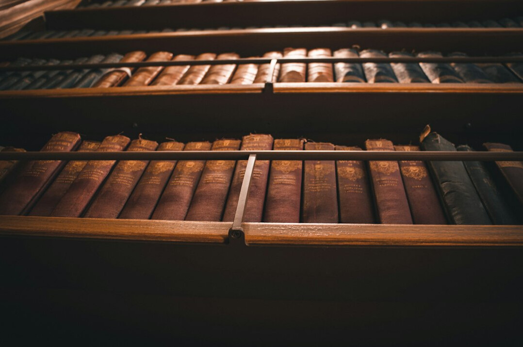 Tall wooden library shelves filled with old books