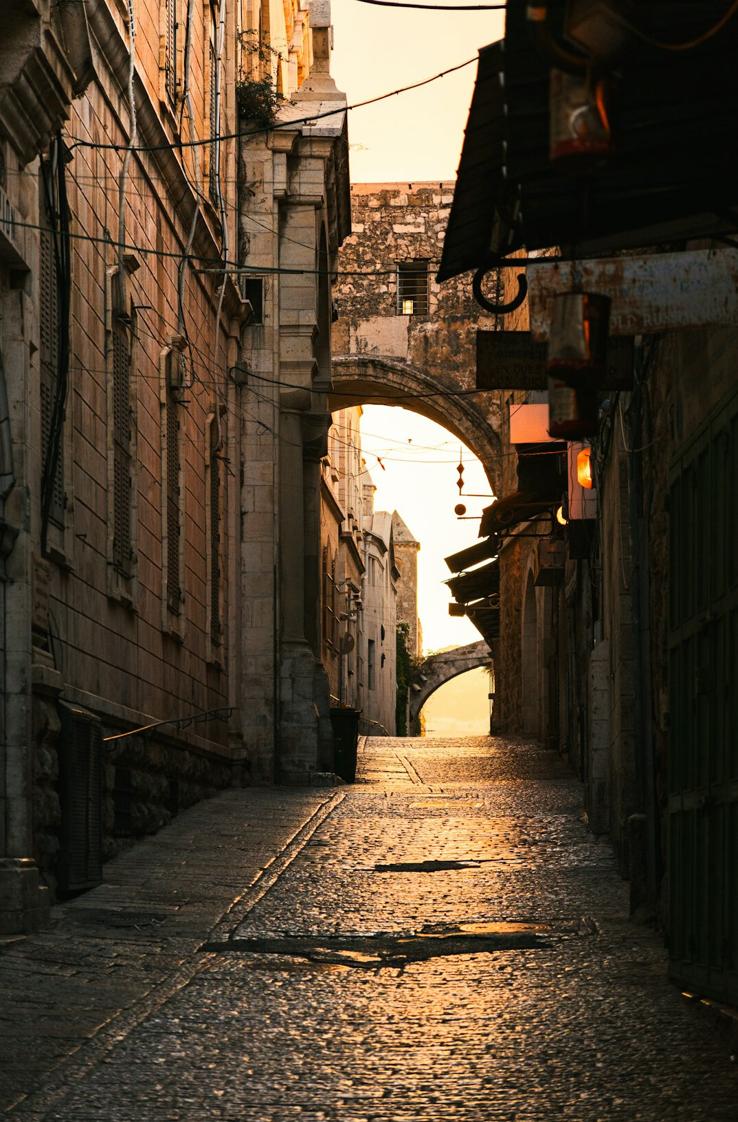 Empty cobblestone street in the old town at dusk with warm lamp light